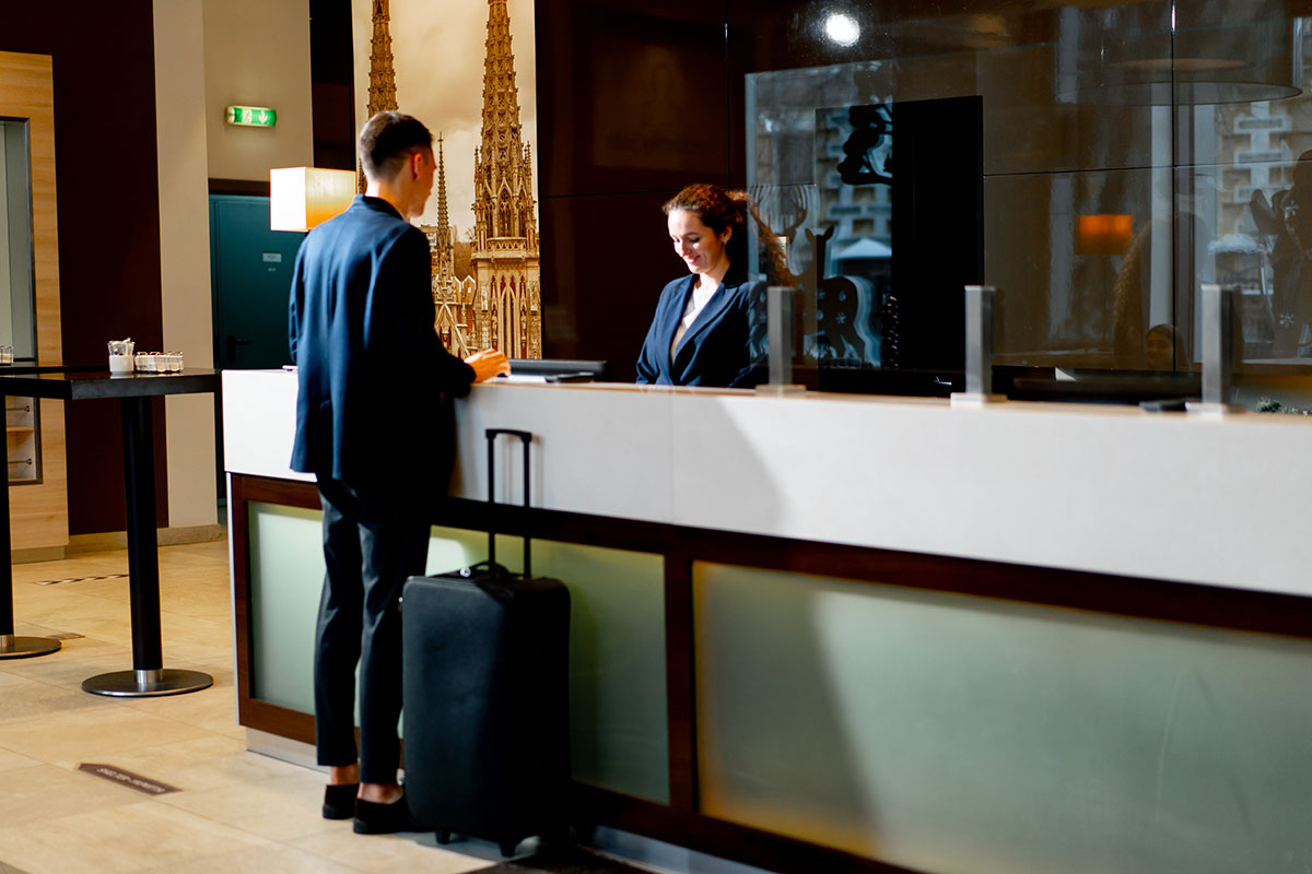 man checking into hotel at reception counter