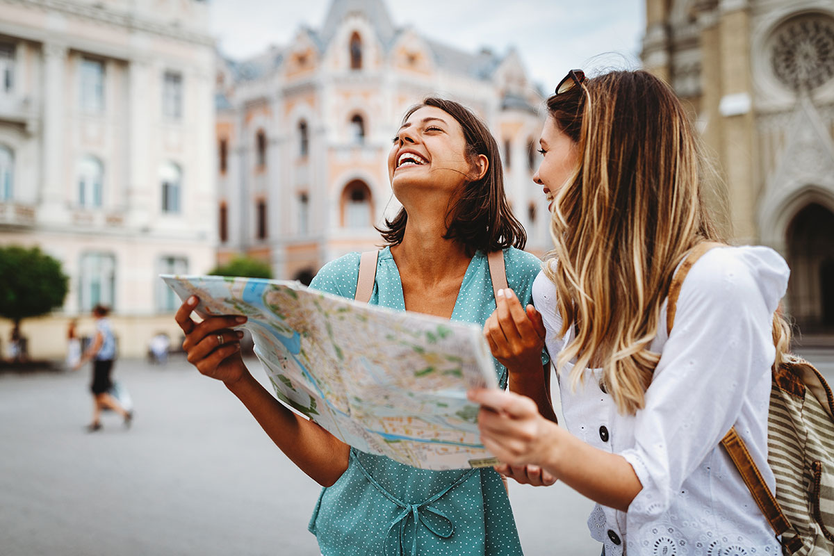 women tourists looking at map